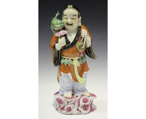 A Chinese famille rose porcelain figure of Liu Hai and his three-legged toad, modelled standing on a pink naturalistic base, 