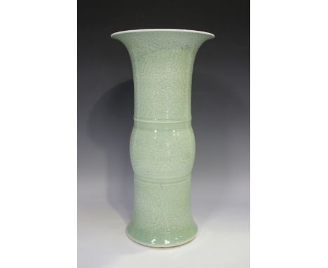 A Chinese Kangxi style celadon glazed porcelain beaker vase, mark of Jiajing but probably 19th century, the exterior carved i