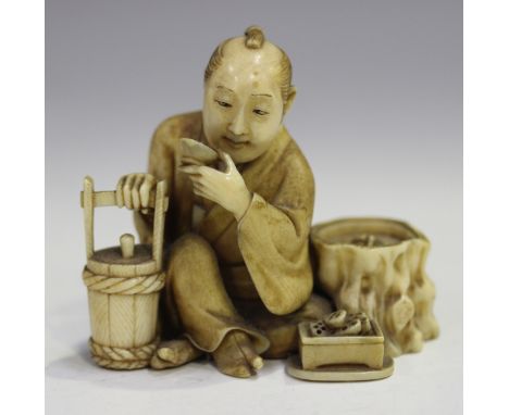 A Japanese carved ivory okimono figure, Meiji period, modelled seated beside a tree stump, drinking from a cup with a bucket 