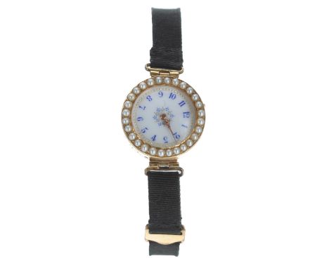 Unusual pretty 18ct pearl set lady's wristwatch with a wind set bezel, enamel dial with blue Arabic numerals, gilt markers an