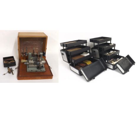 Two watchmaker's tools to include a D.R.G.M bow mill cutter and a pivoting machine; together with two cases containing an ass