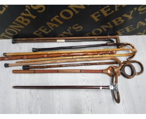 A VINTAGE SHOOTING STICK TOGETHER WITH NINE WALKING STICKS OF VARIOUS DESIGNS