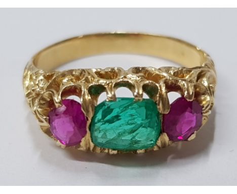 18CT YELLOW GOLD RUBY AND EMERALD THREE STONE RING COMPRISING OF A SINGLE EMERALD STONE IN THE CENTRE SET WITH A ROUND CUT RU