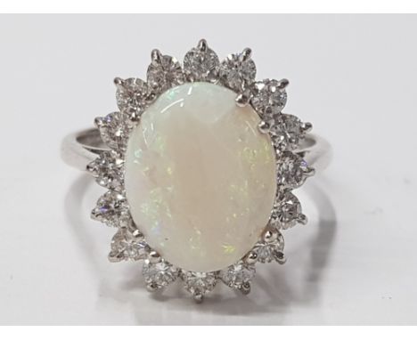 LADIES 18CT WHITE GOLD OPAL AND DIAMOND CLUSTER RING COMPRISING OF A SINGLE OVAL CUT, OPAL SURROUNDED BY A CLUSTER OF A ROUND