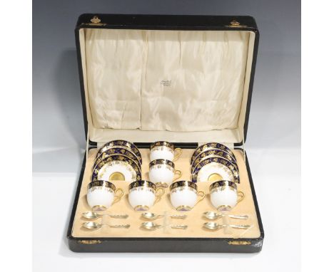 A cased Royal Worcester gilt lined coffee set, dated 1928, gilt with fruiting vine against a cobalt blue band, puce printed f