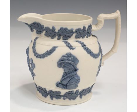 A feldspathic stoneware Queen Caroline commemorative jug, circa 1820, the white body sprigged in high relief blue with a half