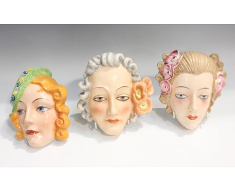 Two Goebel Hummel pottery wall masks, each modelled as a woman's head with flowers in her hair, incised marks to reverse, len