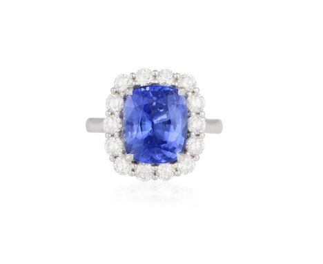 A SAPPHIRE AND DIAMOND CLUSTER RING The cushion-shaped sapphire weighing 5.70cts set in a four-claw setting, within a brillia