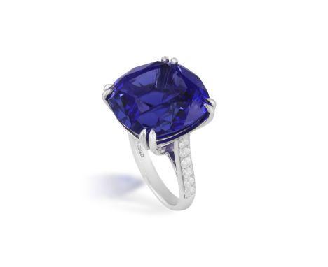 AN IMPRESSIVE TANZANITE AND DIAMOND DRESS RING The cushion-shaped tanzanite weighing 27.12cts within a double four-claw setti