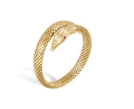 A GOLD AND RUBY SERPENT BRACELET, CIRCA 1960 Designed as a flexible stylised swirling snake, the body decorated with openwork