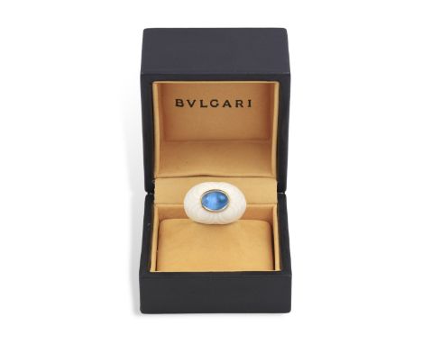 A TOPAZ AND PORCELAIN 'CHANDRA' RING, BY BULGARI, CIRCA 1995 Set with an oval-shaped cabochon blue topaz within collet-settin