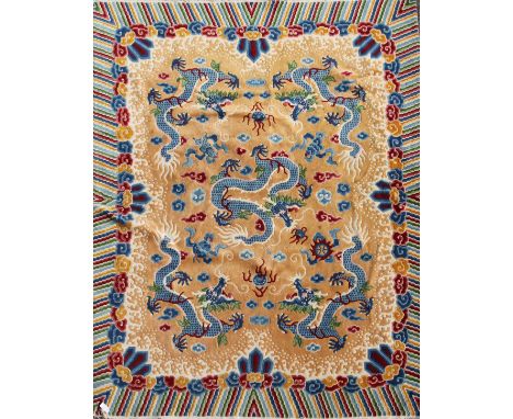 A Chinese carpet, the apricot field with five indigo dragons with a polychrome banded border,