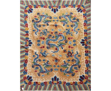 A Chinese carpet, the apricot field with five indigo dragons with a polychrome banded border,