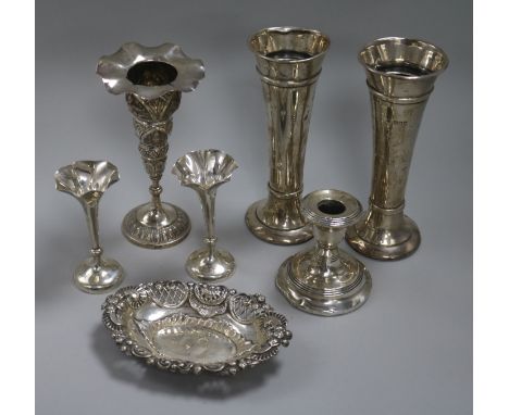 Two pairs of silver vases, one other vase, a silver candlestick and a silver dish.