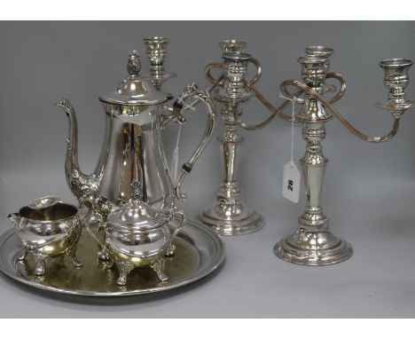 A pair of plated candelabrum, a three-piece plated coffee set, a circular tray and a dwarf candlestick
