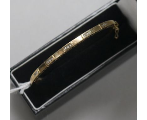 A 9ct gold and diamond hinged bangle, with pierced decoration, in fitted case.