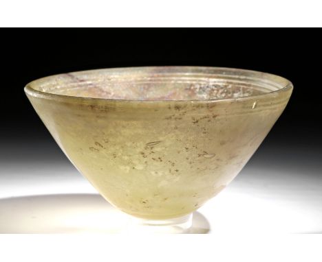 Roman, early Imperial Period, ca. 1st century CE. A gorgeous mold-made, translucent glass bowl of a pale green hue with occas