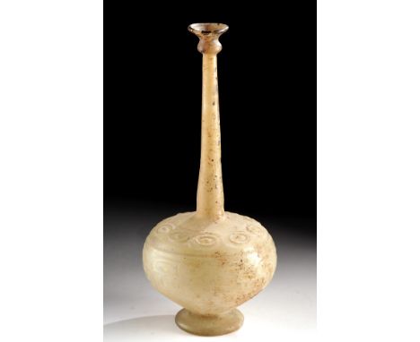 Near East, Islamic, ca. 12th to 13th century CE. A beautiful flask of a tall stature, mold-formed from near-opaque glass of a