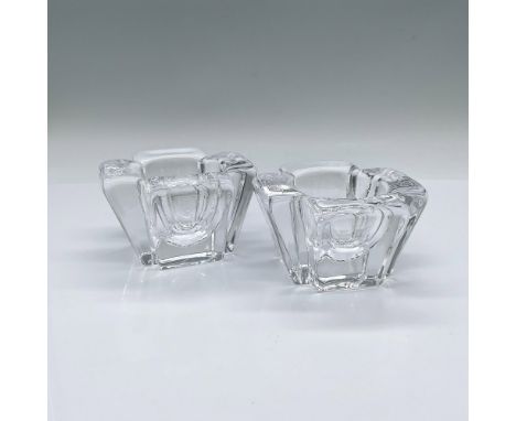 A set of 2 four petal shaped votive candle holders. Orrefors marked. Artist: Anna EhrnerIssued: 20th centuryDimensions: 3.75"