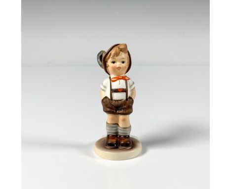 A small hand painted figure of a smiling boy dressed in a traditional outfit with his hands in his pockets. M.I. Hummel Club.