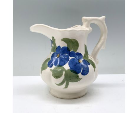 A cream-colored pitcher graced with the delicate beauty of blue flax flowers hand-painted at its center. Clinchfield backstam