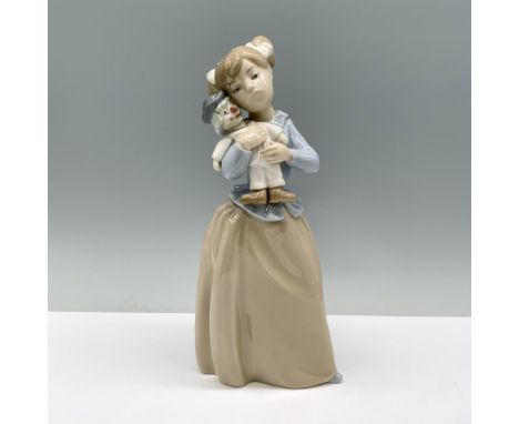 Glossy finish porcelain sculpture depicting a little girl tenderly caressing her doll. Nao By Lladro backstamp. Dimensions: 3