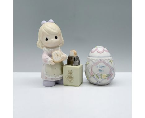 The Precious Moments figurine depicts a young girl in a pink floral dress and kitchen apron, happily preparing her morning to