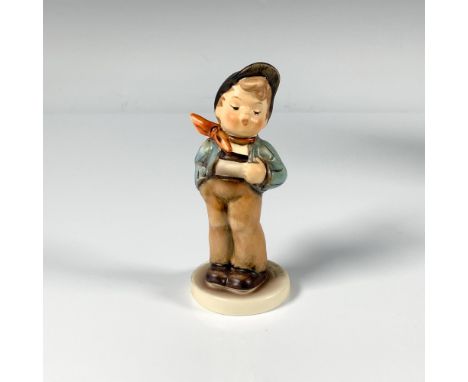 A small hand painted figure of a young boy wearing brown pants, a blue jacket and red scarf. M.I. Hummel Club. Goebel backsta