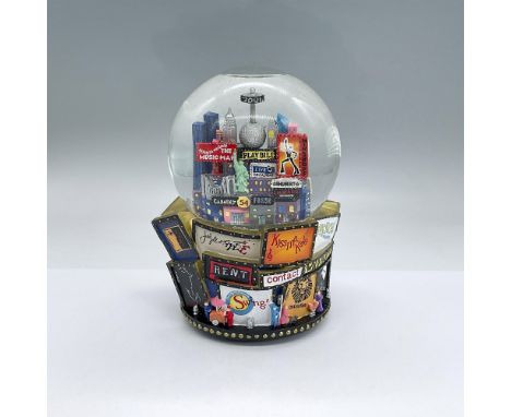 Resin and glass snow globe with detailed raised scenes of Broadway theatre marquees. In the center is the Times Square Ball, 