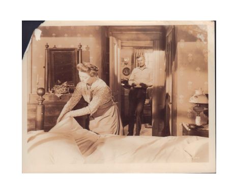 Featuring woman bed-making as gentleman stands in doorway holding note. Presumably a film still or scene from movie released 