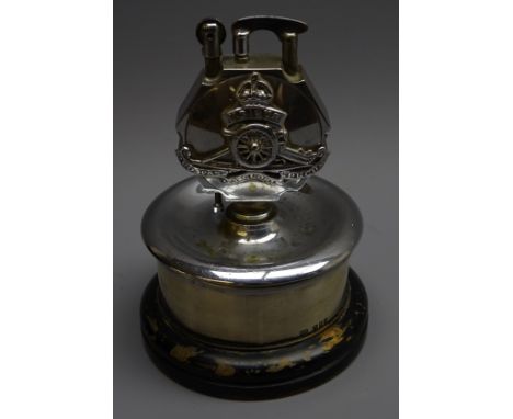 Royal Artillery presentation chromed metal table lighter, circular stand with silver band hallmarked London 1956 and ebonised