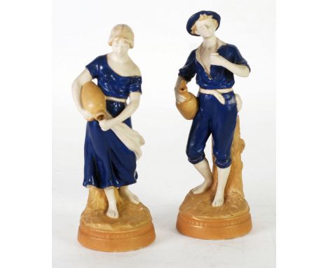 A PAIR OF EARLY TWENTIETH CENTURY ROYAL DUX PORCELAIN FIGURES of a man holding a jug and beaker and a lady pouring from a jug