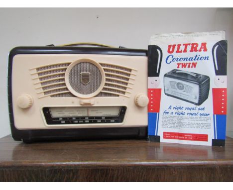 An Ultra R786 Coronation Twin portable valve radio housed in a dark plum and cream Bakelite and plastic case with carrying ha