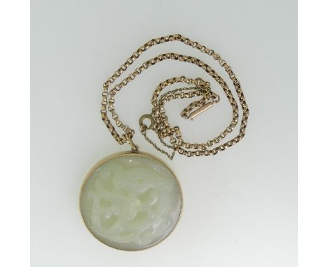 A circular pierced carved pale jade Pendant, mounted in 9ct gold, on a 9ct gold chain, the chain 5.7g, the pendant 4.4cm diam