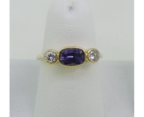 A colour change sapphire and diamond three stone Ring, the central oval sapphire, approx 1ct, with a circular cut diamond on 