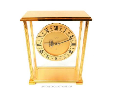 An Imhof, Swiss Made brass mantle clock, having four glazed sides and a hand wound mechanical movement, 18 x 14 x 7cm.