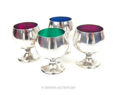 A set of four American silver and enamel liqueur cups with interior enamelled colours of one blue, one green and two purple,a