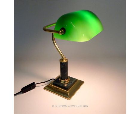 A brass banker's lamp with a green glass adjustable shade, raised on a green marble cylindrical stem with green marble to the