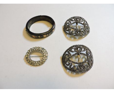 A pair of cut steel buckles, a piqué work bangle, damaged, and a paste brooch