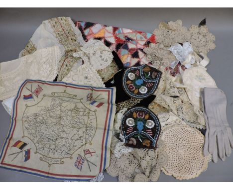 A quantity of textiles, including linen table cloth sheets, a patchwork pillow case with blanket stitching detail, a WWII pro