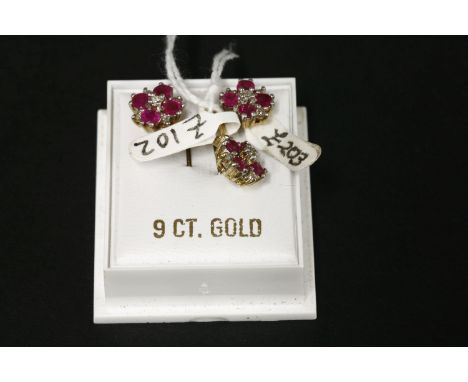 A 9ct gold diamond and ruby pendant and earring suite