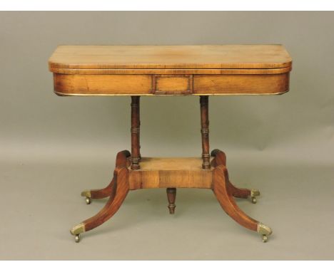 A Regency mahogany fold over card table, on a platform base and sabre legs, 90cm wide, 66cm high