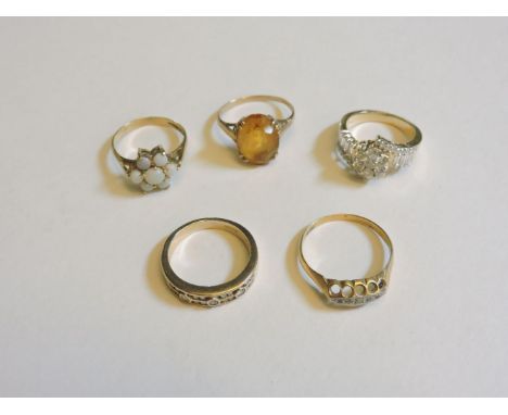 A 9ct gold diamond band ring, a five stone diamond ring, a silver opal ring, a gold citrine ring, and a synthetic moissanite 