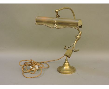 An early 20th century brass desk lamp, with a detachable light and weighted base, 43cm high