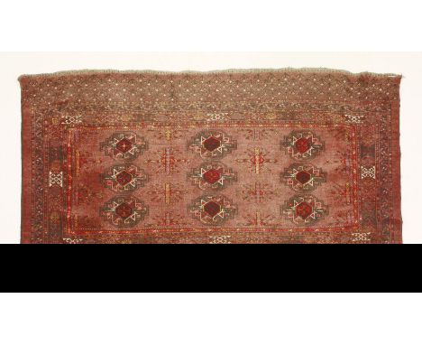 A Turkoman rug, with geometric motifs on a red field, 192 x 105cm