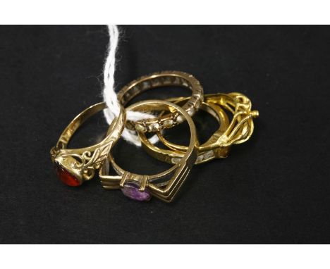 A gold flower head ring, tested as approximately 18ct gold, a 9ct gold amethyst ring, a gold amber ring tested as approximate