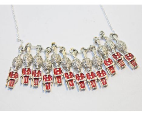 A silver necklace formed as 12 red enamel Queen's Guard pendants marked 'Sterling'.