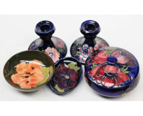 Five items of Moorcroft pottery comprising a lidded jar, a pair of candlesticks and two small dishes.  CONDITION REPORT - one