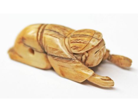 A 19th Century Japanese ivory netsuke formed as a figure lying down with arms out, length 4.5cm. CONDITION REPORT - left hand