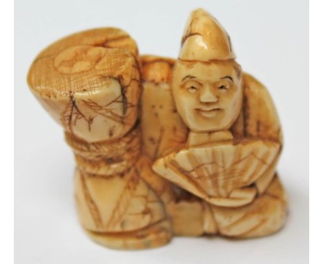 A 19th Century Japanese ivory netsuke formed as a figure with arm round a bag and holding a fan, signature to base, height 3.